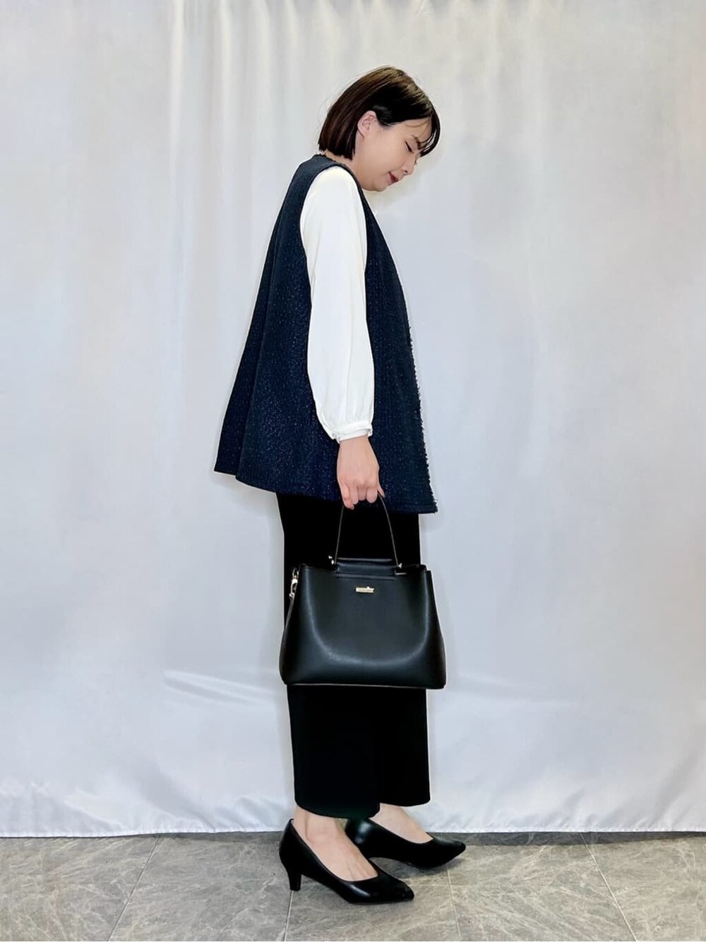 ブルー系のベスト、ホワイト系のシャツ/ブラウス、ブラック系のその他パンツを着用したレディースの冬コーディネートの2枚目の写真