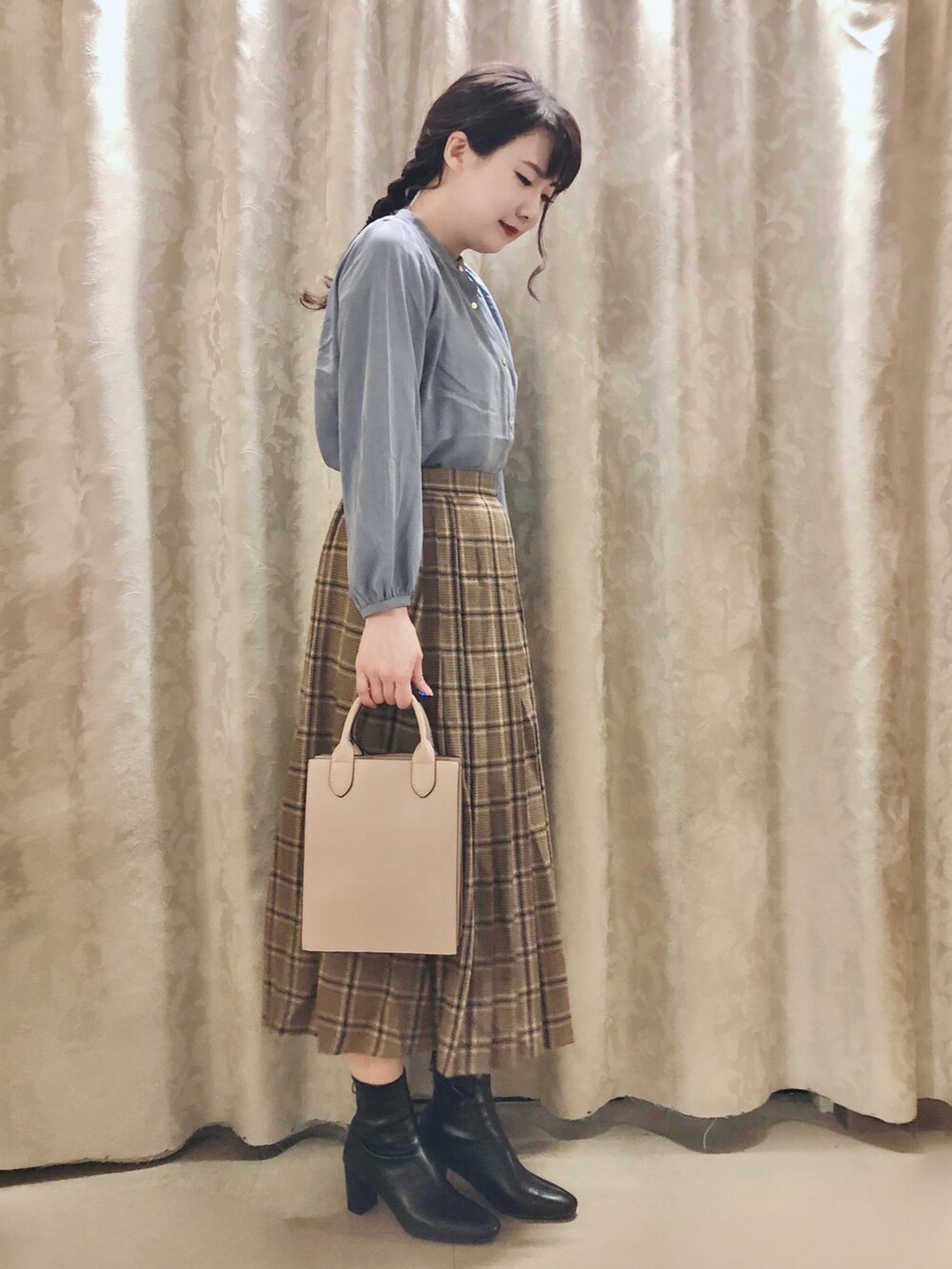 ベージュ系のスカート、グレー系のショルダーバッグ、ブラック系のブーツを着用したレディースの秋コーディネートの2枚目の写真