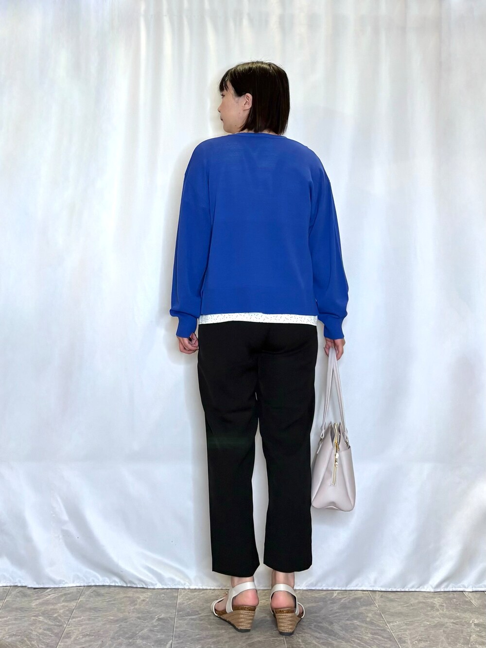 ブルー系のカーディガン/ボレロ、ホワイト系のシャツ/ブラウス、ブラック系のその他パンツを着用したレディースの春コーディネートの3枚目の写真
