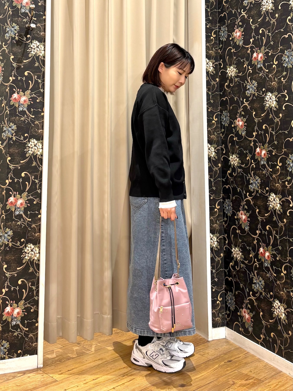 ブラック系のカーディガン/ボレロ、ホワイト系のTシャツ/カットソー、ブルー系のデニムスカートを着用したレディースの秋コーディネートの2枚目の写真