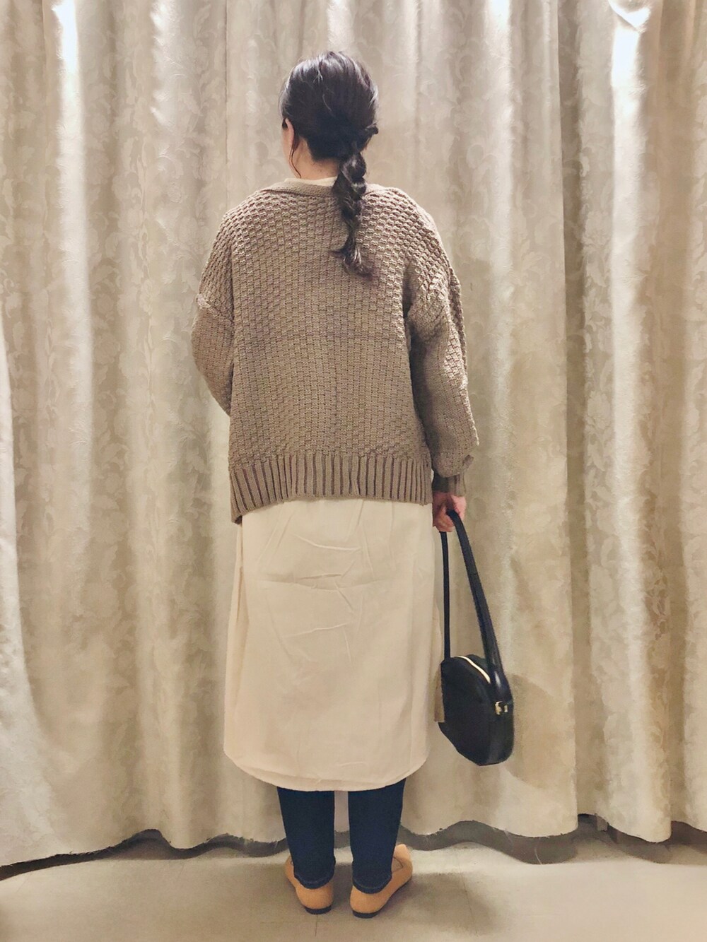 イエロー系のパンプス、ブラック系のショルダーバッグ、ベージュ系のカーディガン/ボレロを着用したレディースの秋コーディネートの3枚目の写真