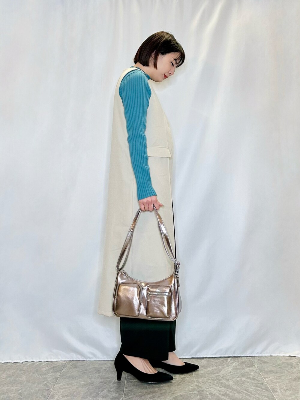 ベージュ系のベスト、その他のショルダーバッグ、ブラック系のパンプスを着用したレディースの冬コーディネートの2枚目の写真