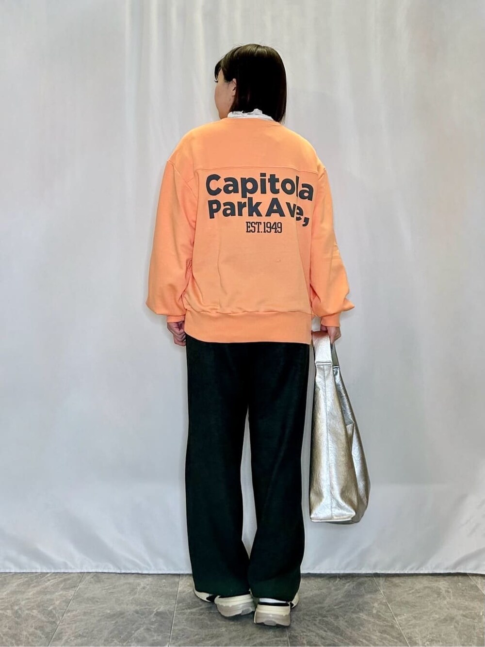 オレンジ系のスウェット、ホワイト系のTシャツ/カットソー、ブラック系のその他パンツを着用したレディースの冬コーディネートの3枚目の写真