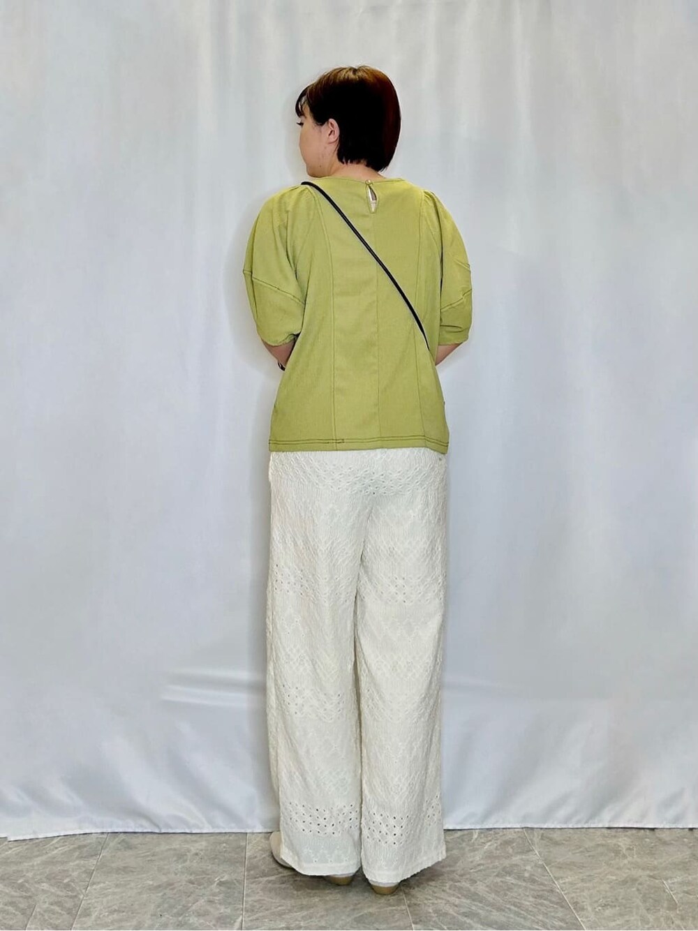 グリーン系のTシャツ/カットソー、ホワイト系のその他パンツ、ゴールド系のその他シューズを着用したレディースの春コーディネートの3枚目の写真