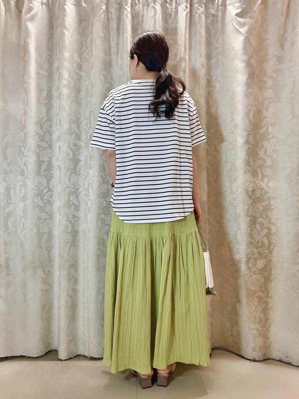 ホワイト系のTシャツ/カットソー、ブラウン系のトートバッグ、ベージュ系のサンダルを着用したレディースの春コーディネートの3枚目の写真