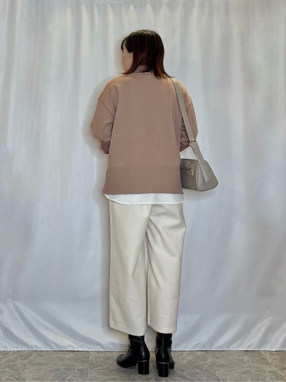 ブラウン系のニット/セーター、ホワイト系のその他パンツ、ブラック系のブーツを着用したレディースの冬コーディネートの3枚目の写真
