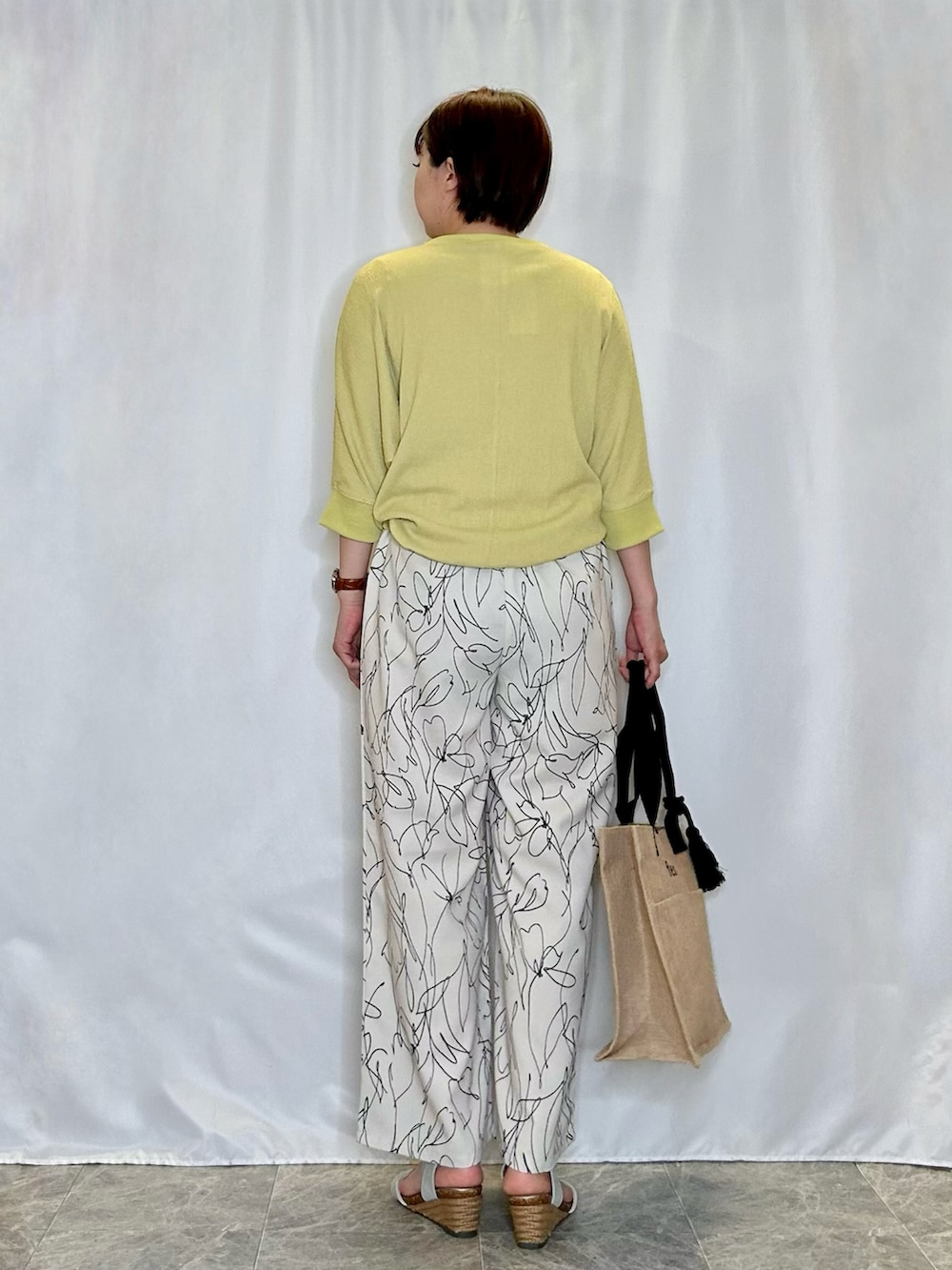 イエロー系のTシャツ/カットソー、シルバー系のサンダル、ホワイト系のその他パンツを着用したレディースの春コーディネートの3枚目の写真