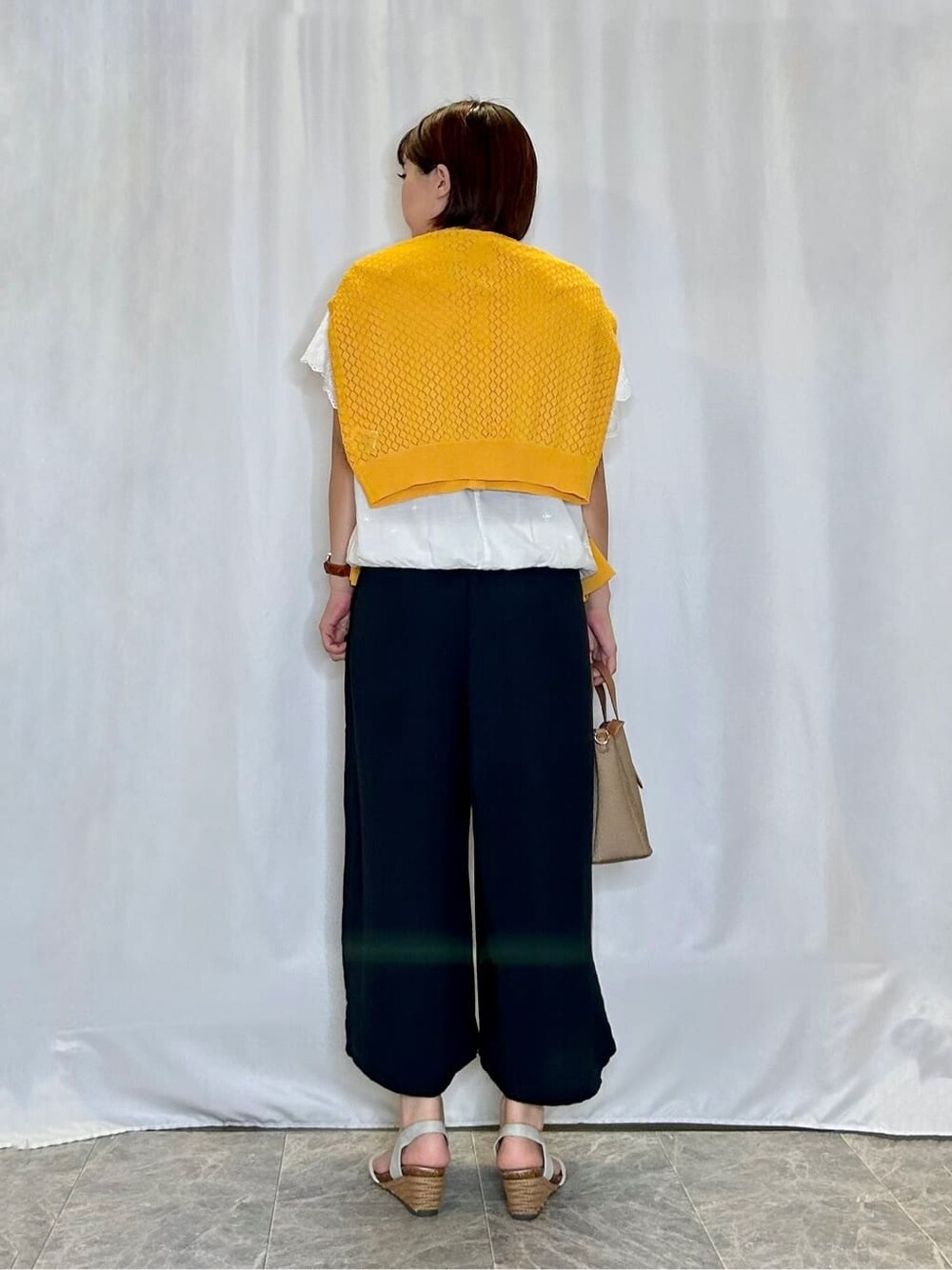イエロー系のカーディガン/ボレロ、ホワイト系のTシャツ/カットソー、ブルー系のその他パンツを着用したレディースの夏コーディネートの3枚目の写真