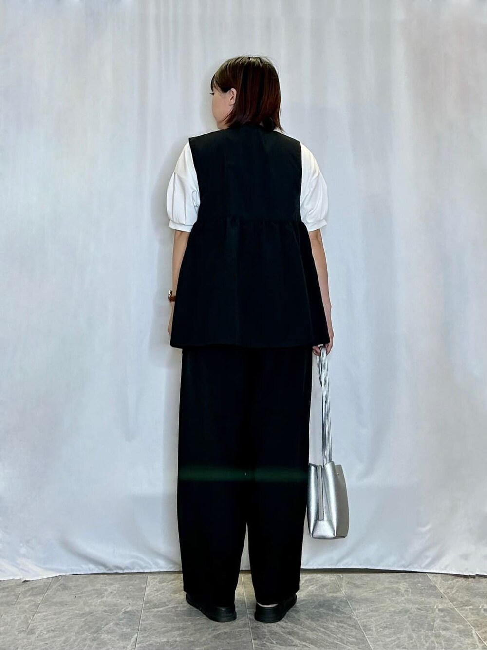 ブラック系のベスト、ホワイト系のTシャツ/カットソー、ブラック系のその他パンツを着用したレディースの夏コーディネートの3枚目の写真