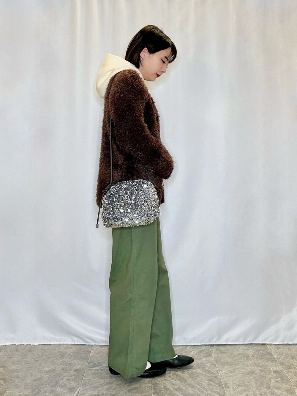 ブラウン系のカーディガン/ボレロ、ホワイト系のスウェット、ブラック系のパンプスを着用したレディースの冬コーディネートの2枚目の写真