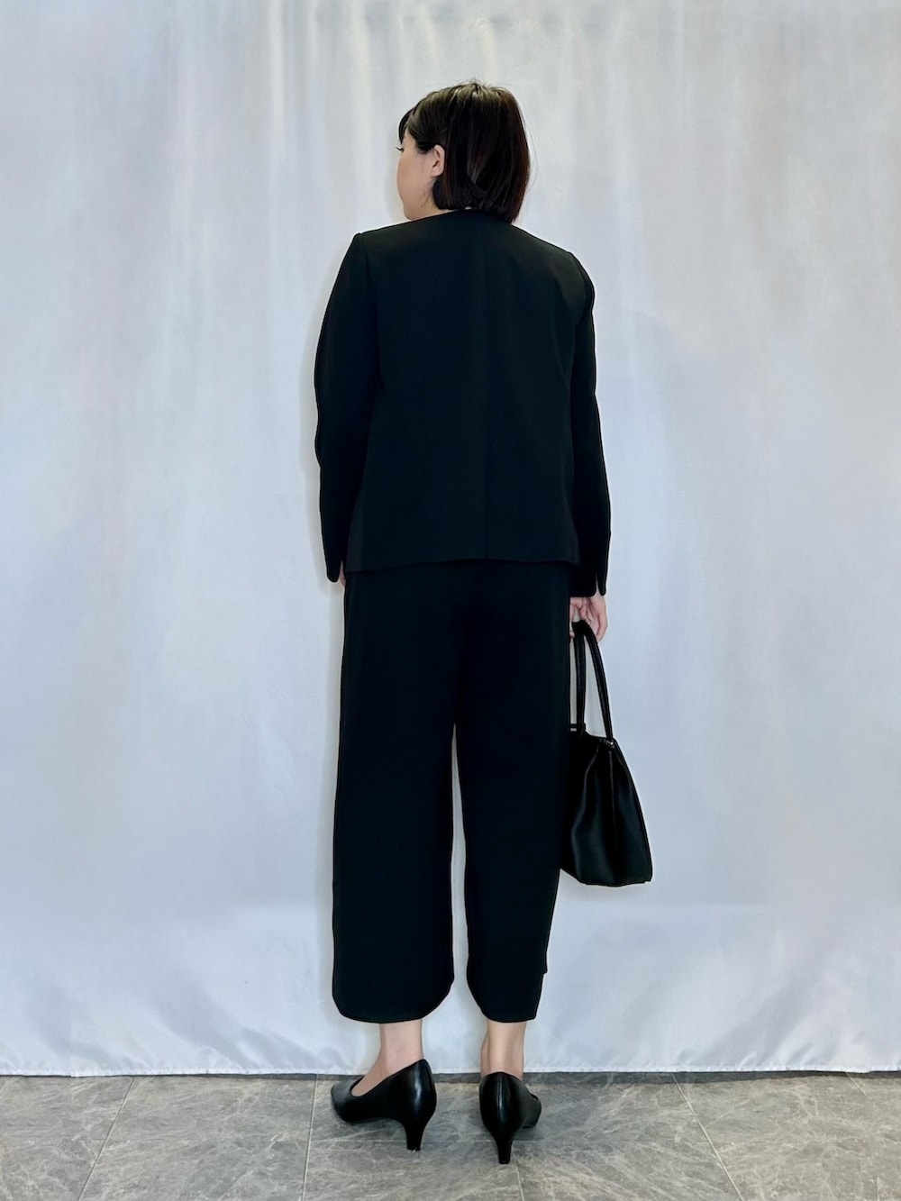 ブラック系のパンプス、ブラック系のその他パンツ、ブラック系のトートバッグを着用したレディースの冬コーディネートの3枚目の写真