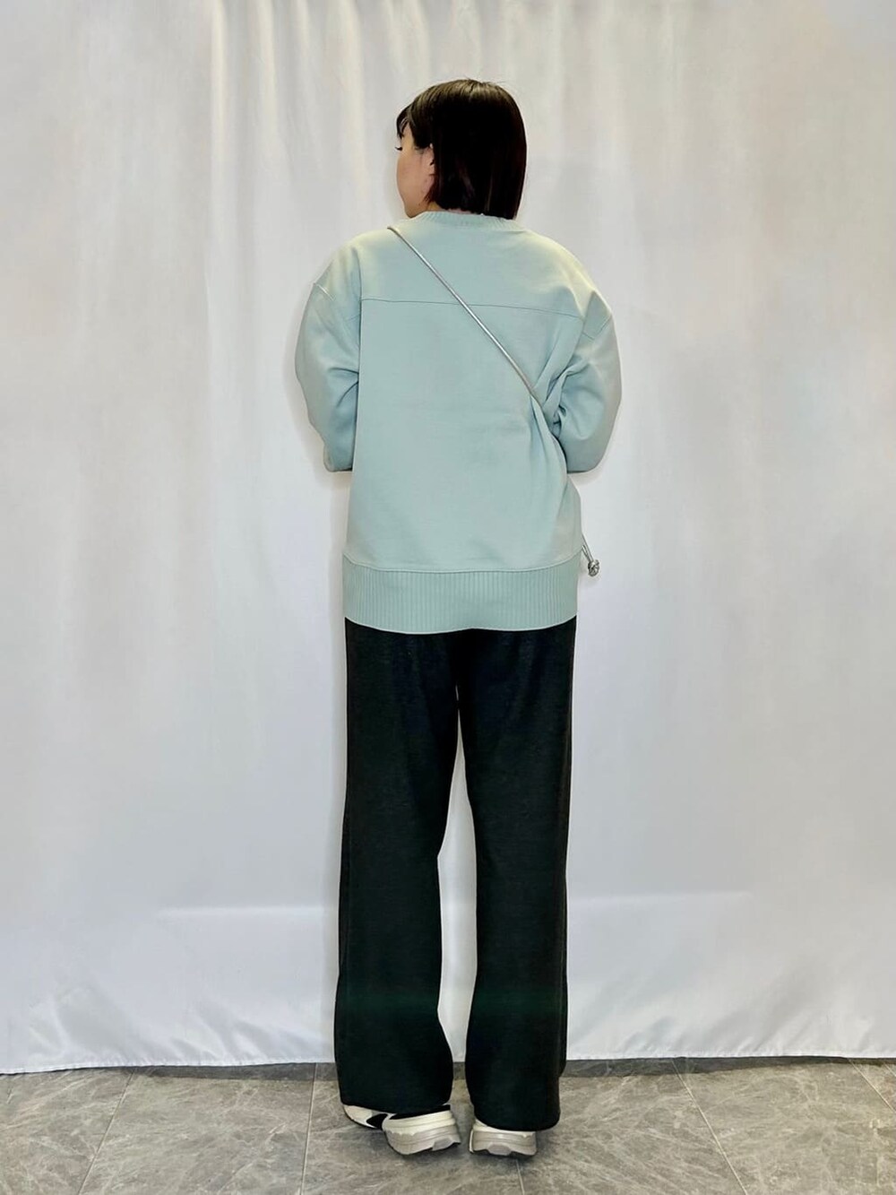グリーン系のTシャツ/カットソー、ブラック系のその他パンツ、シルバー系のショルダーバッグを着用したレディースの冬コーディネートの3枚目の写真