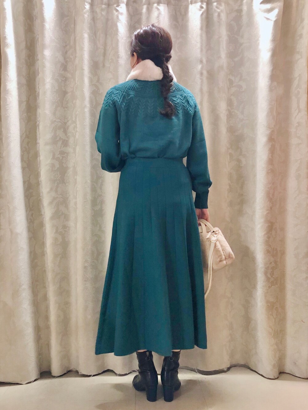 ホワイト系のショルダーバッグ、ブラック系のブーツ、グリーン系のニット/セーターを着用したレディースの秋コーディネートの3枚目の写真