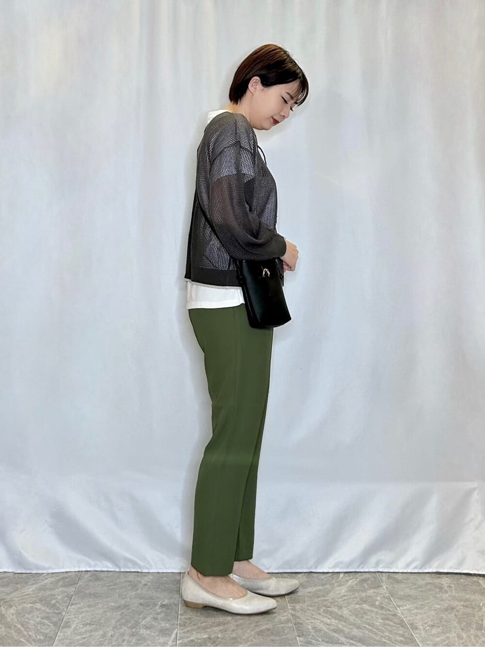グレー系のその他トップス、グリーン系のその他パンツ、ゴールド系のその他シューズを着用したレディースの春コーディネートの2枚目の写真