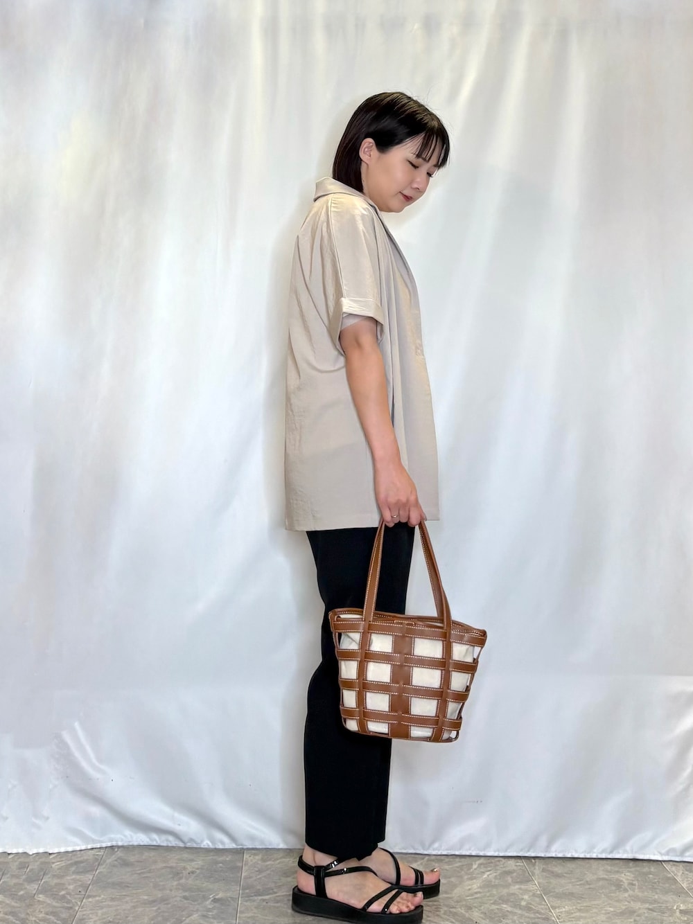 ベージュ系のテーラードジャケット、ホワイト系のTシャツ/カットソー、ブラック系のその他パンツを着用したレディースの夏コーディネートの2枚目の写真