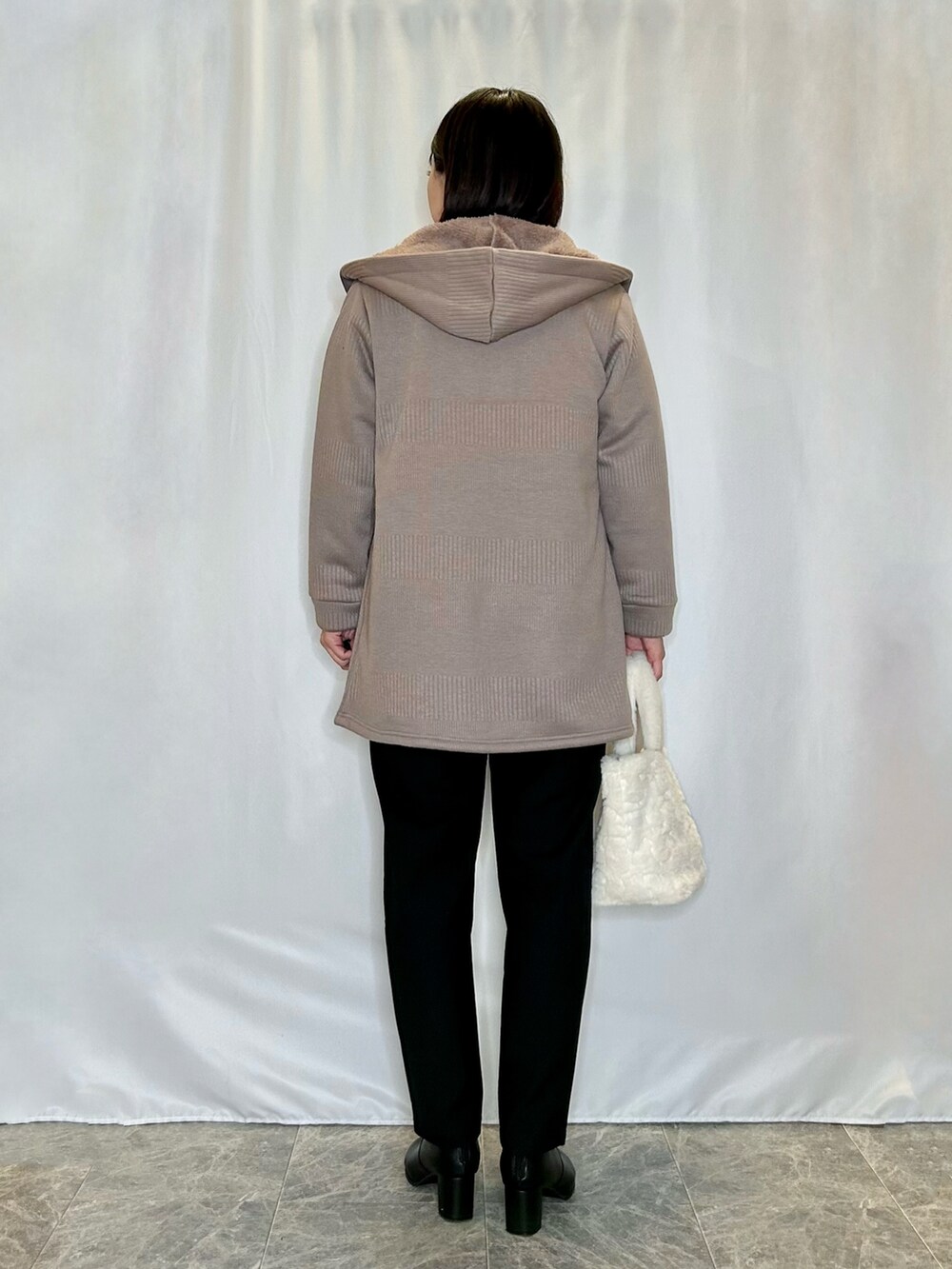 ベージュ系のトートバッグ、ブラック系のその他パンツ、ブラック系のブーツを着用したレディースの冬コーディネートの3枚目の写真