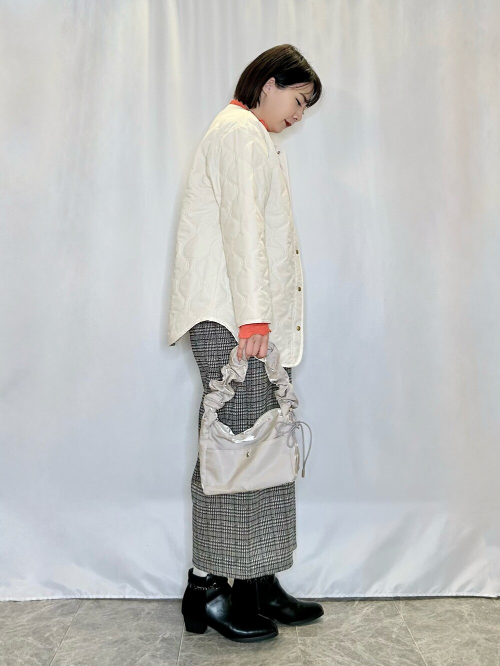 ホワイト系のブルゾン、ベージュ系のその他パンツ、ブラック系のブーツを着用したレディースの冬コーディネートの2枚目の写真