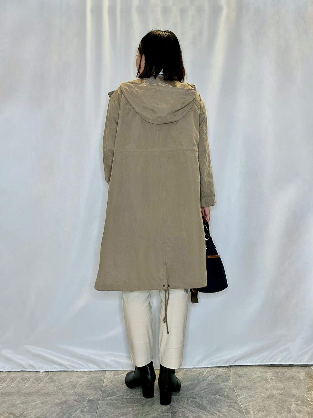 ホワイト系のその他パンツ、ブラック系のブーツ、ブルー系のトートバッグを着用したレディースの秋コーディネートの3枚目の写真