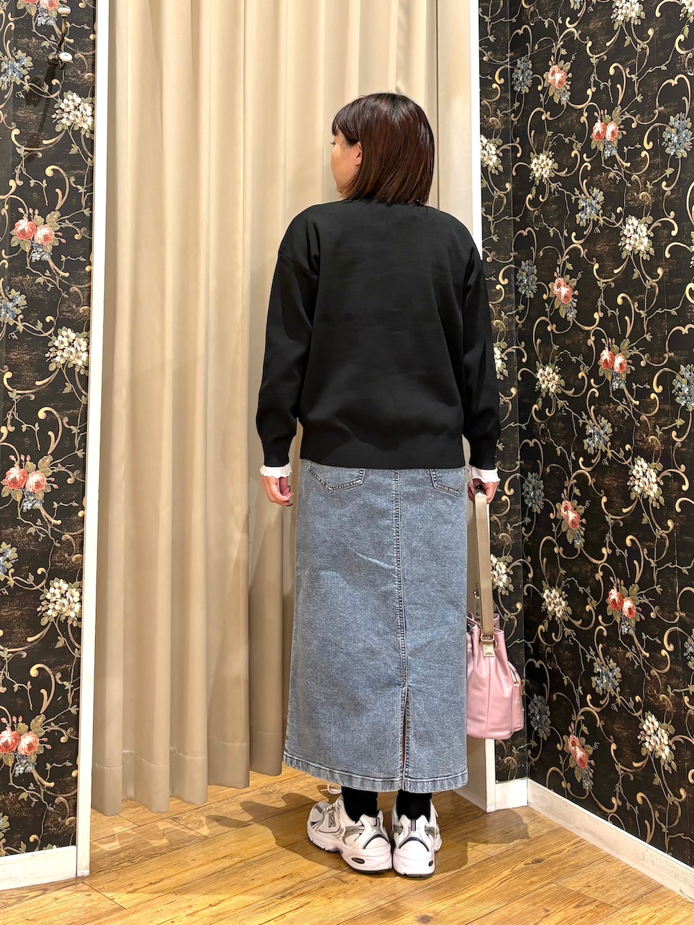 ブラック系のカーディガン/ボレロ、ホワイト系のTシャツ/カットソー、ブルー系のデニムスカートを着用したレディースの秋コーディネートの3枚目の写真