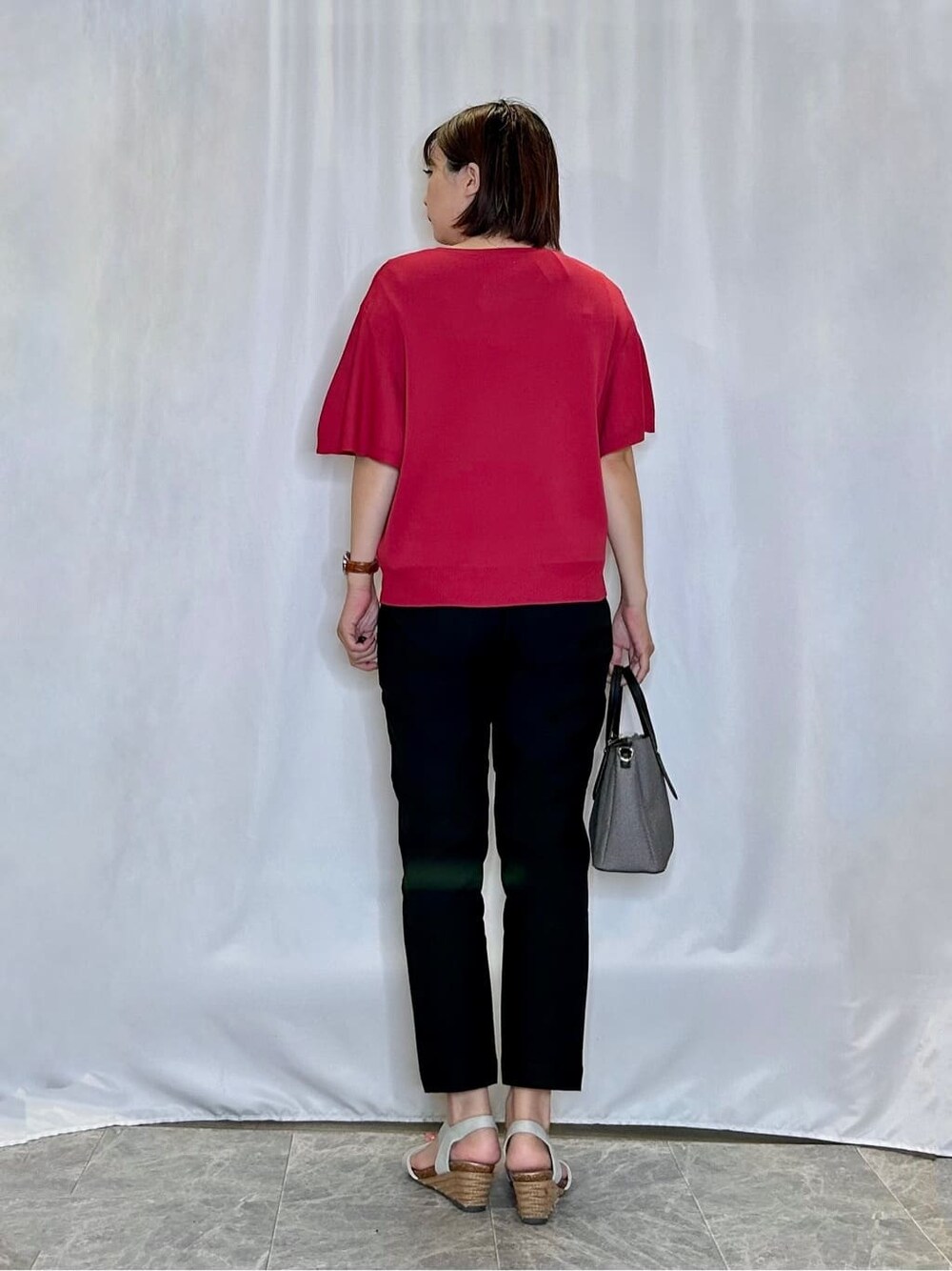 レッド系のニット/セーター、ブラック系のその他パンツ、シルバー系のサンダルを着用したレディースの夏コーディネートの3枚目の写真