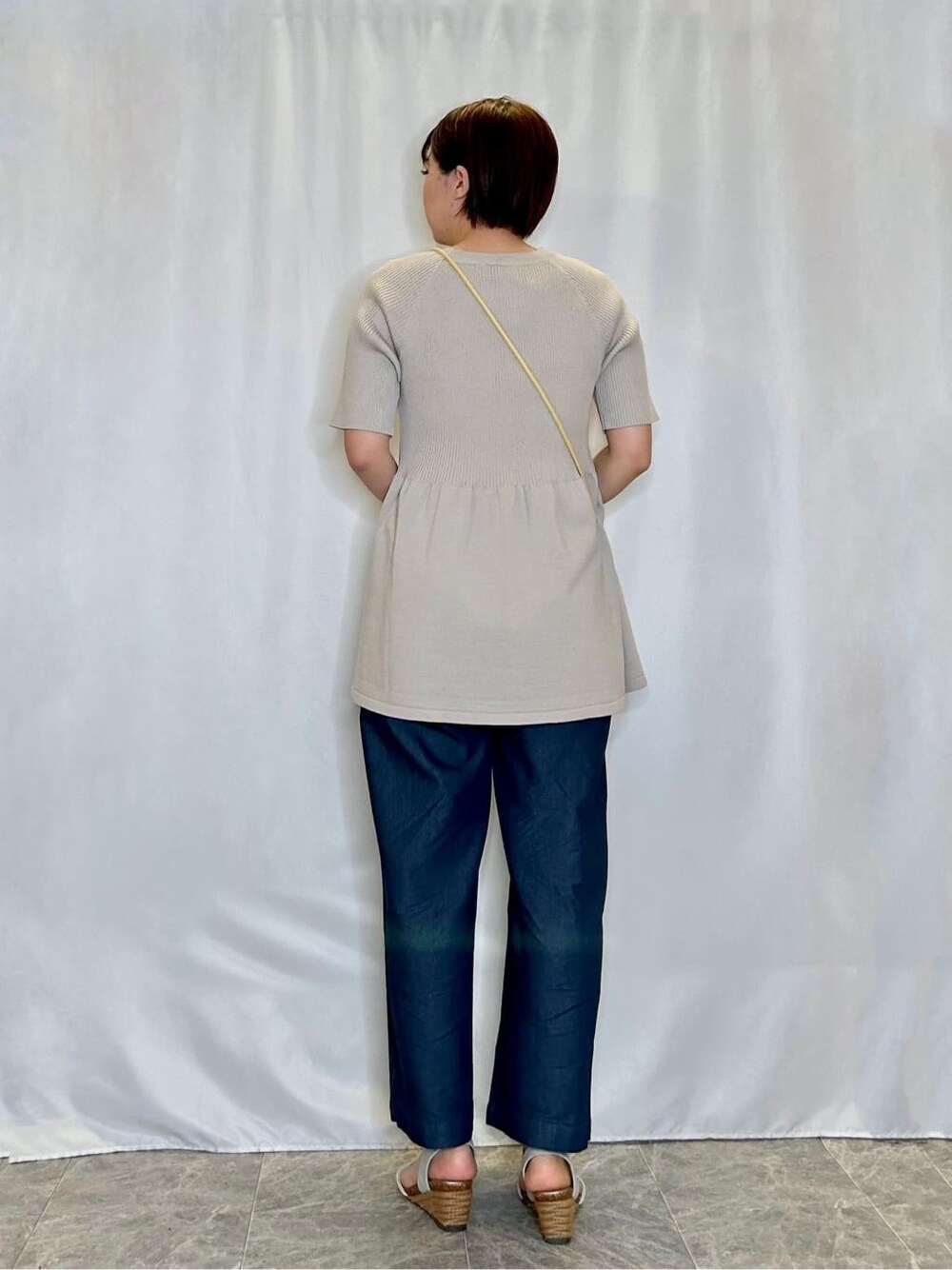ベージュ系のニット/セーター、ブルー系のその他パンツ、シルバー系のサンダルを着用したレディースの夏コーディネートの3枚目の写真