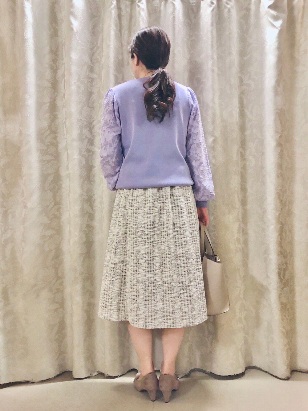 ベージュ系のパンプス、グレー系のトートバッグ、パープル系のニット/セーターを着用したレディースの春コーディネートの3枚目の写真