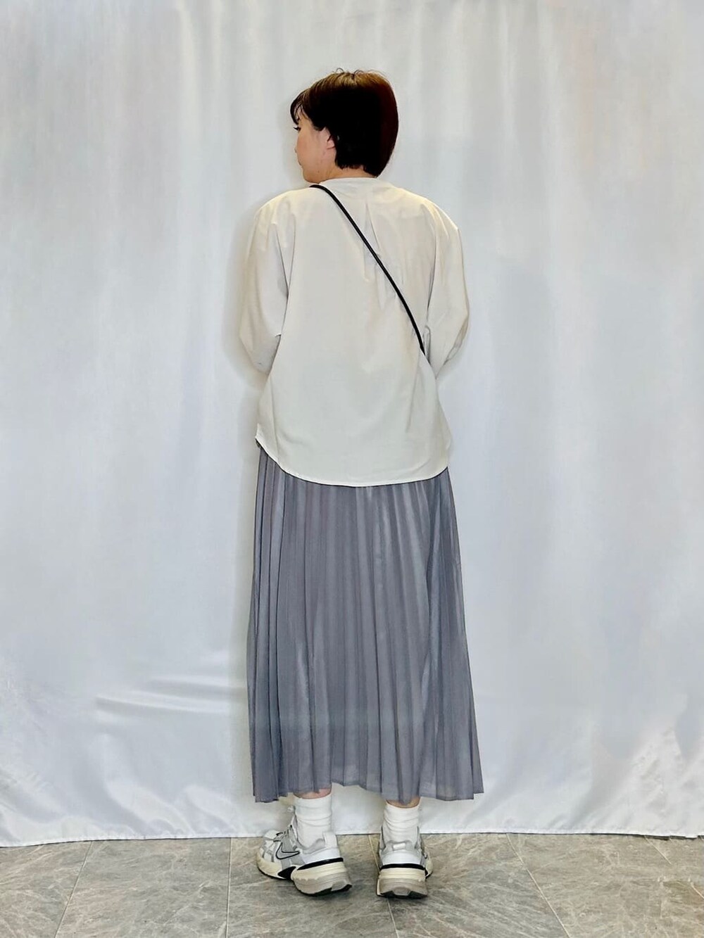 ベージュ系のシャツ/ブラウス、グレー系のスカート、ブラック系のショルダーバッグを着用したレディースの春コーディネートの3枚目の写真