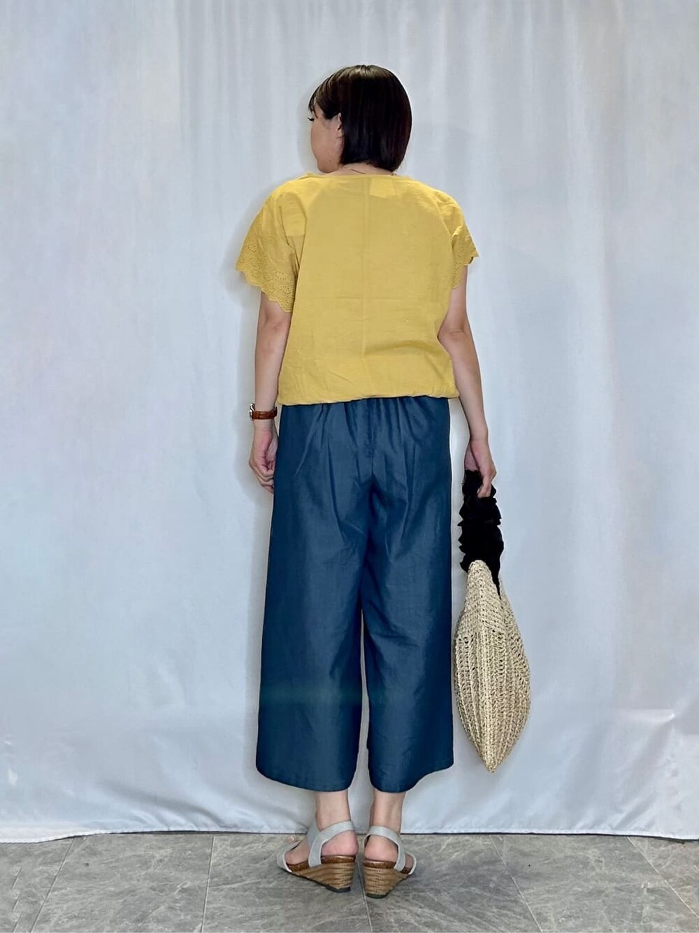 イエロー系のTシャツ/カットソー、ブルー系のデニムパンツ、シルバー系のサンダルを着用したレディースの夏コーディネートの3枚目の写真