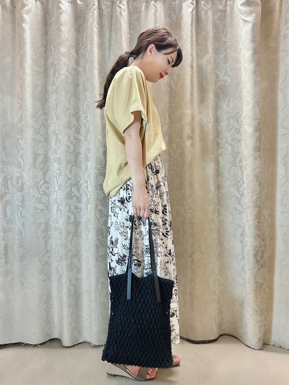 イエロー系のシャツ/ブラウス、ブラック系のトートバッグ、ブラウン系のサンダルを着用したレディースの夏コーディネートの2枚目の写真