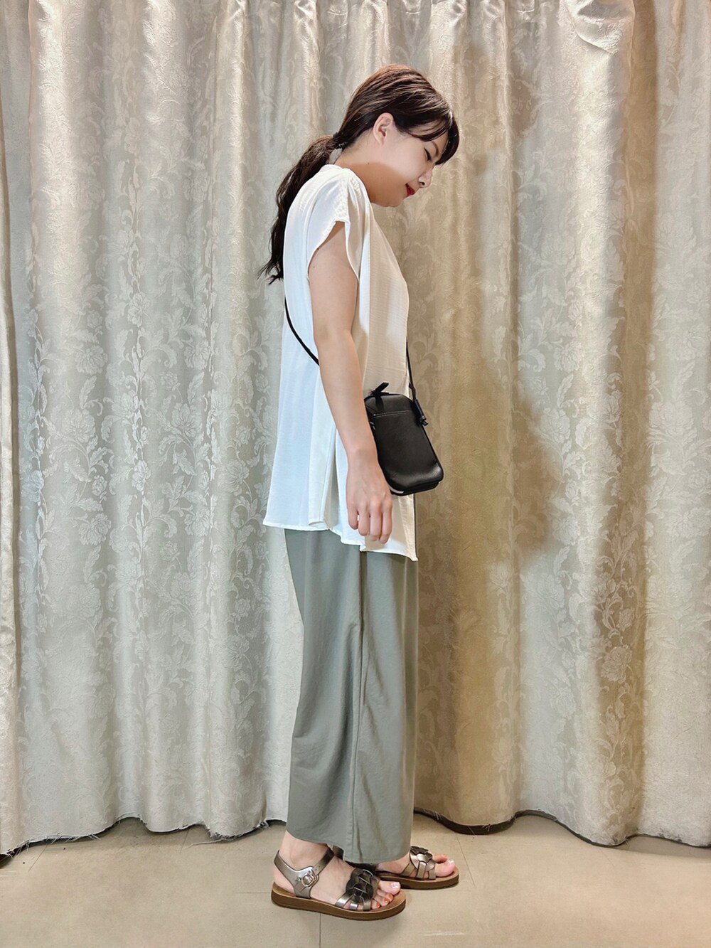 ベージュ系のタンクトップ、その他のサンダル、グリーン系のその他パンツを着用したレディースの夏コーディネートの2枚目の写真