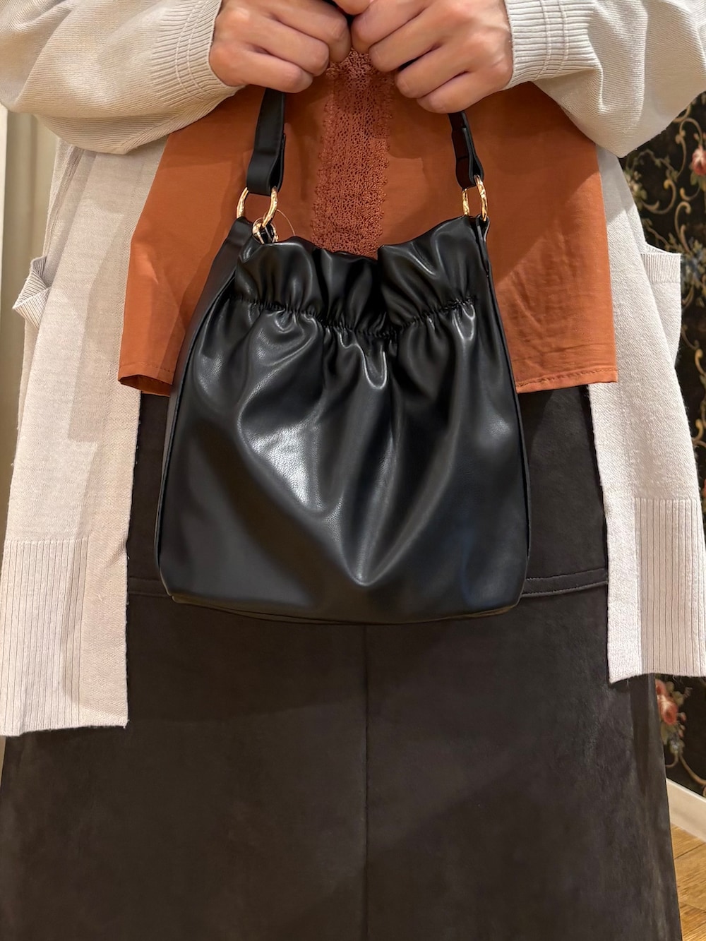 グレー系のカーディガン/ボレロ、オレンジ系のシャツ/ブラウス、グレー系のスカートを着用したレディースの秋コーディネートの5枚目の写真