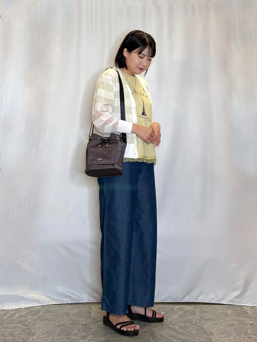ホワイト系のカーディガン/ボレロ、イエロー系のTシャツ/カットソー、ブルー系のデニムパンツを着用したレディースの夏コーディネートの2枚目の写真