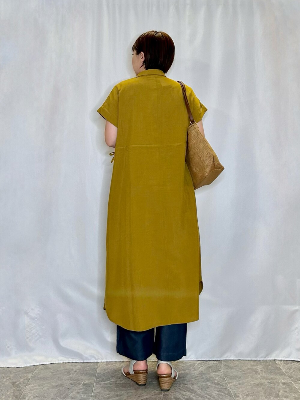 シルバー系のサンダル、イエロー系のワンピース、ブルー系のその他パンツを着用したレディースの春コーディネートの3枚目の写真