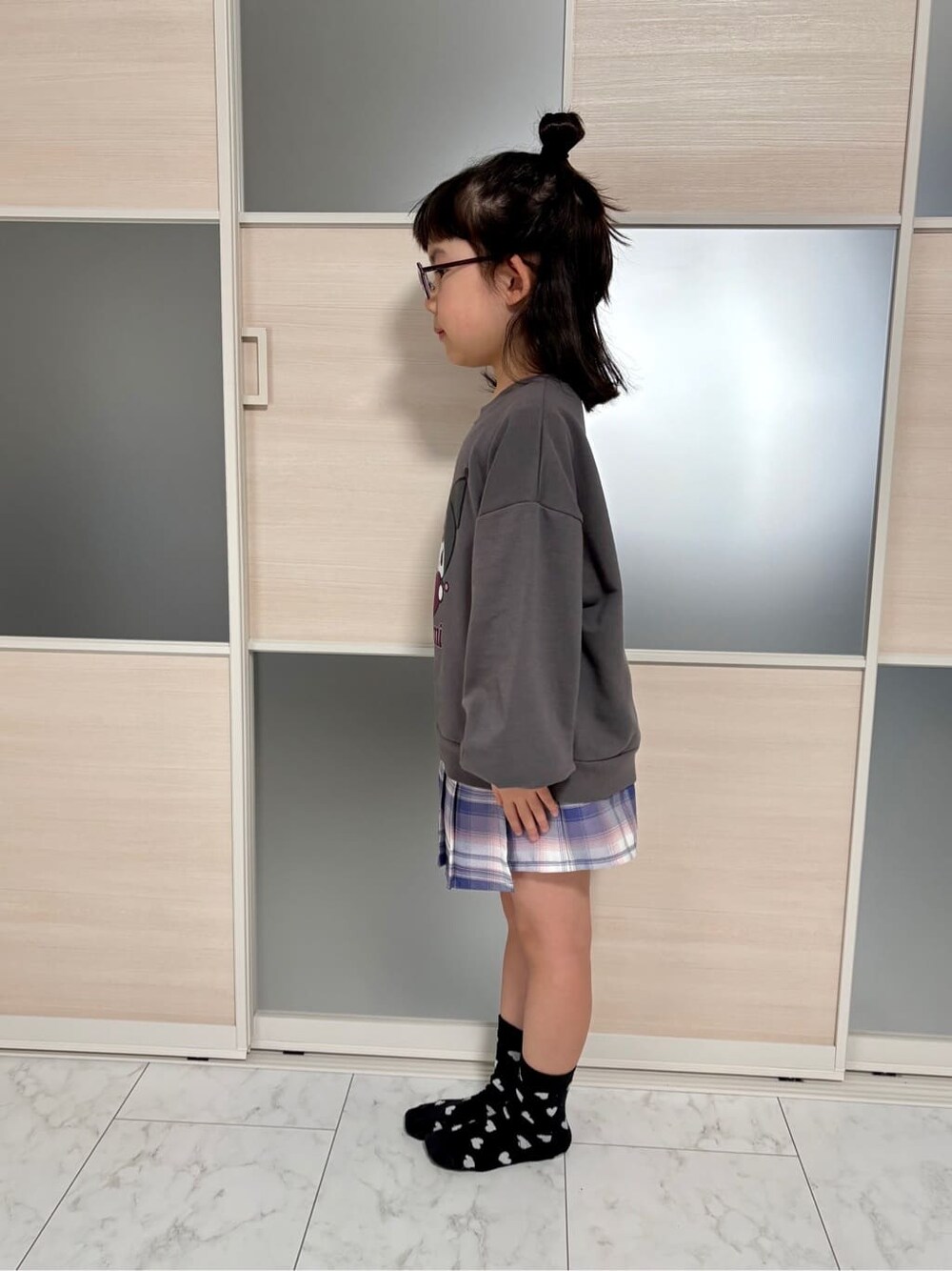 グレー系のスウェット、パープル系のスカートを着用したレディースの冬コーディネートの2枚目の写真