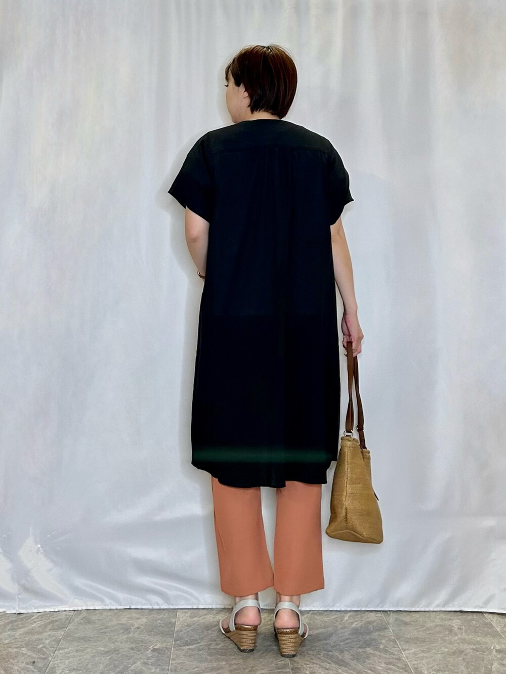 ブラック系のワンピース、ベージュ系のショルダーバッグ、シルバー系のサンダルを着用したレディースの春コーディネートの3枚目の写真