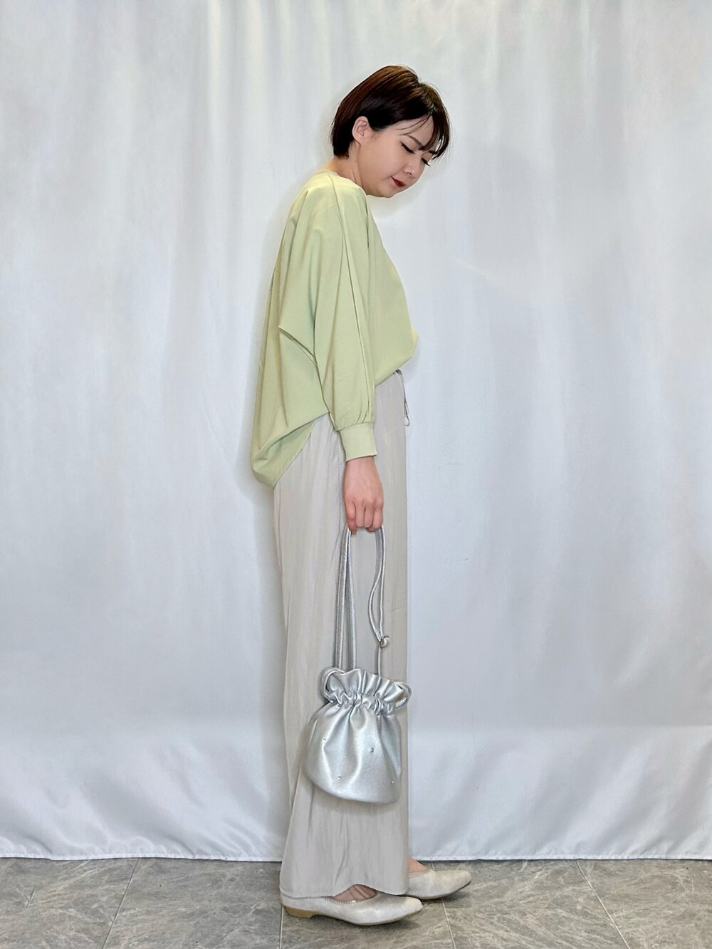 ベージュ系のその他パンツ、ゴールド系のその他シューズ、シルバー系のショルダーバッグを着用したレディースの春コーディネートの2枚目の写真