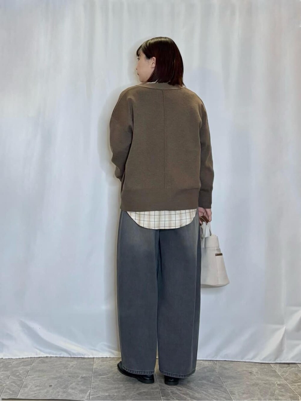 ブラウン系のカーディガン/ボレロ、ベージュ系のシャツ/ブラウス、ブラック系のデニムパンツを着用したレディースの秋コーディネートの3枚目の写真
