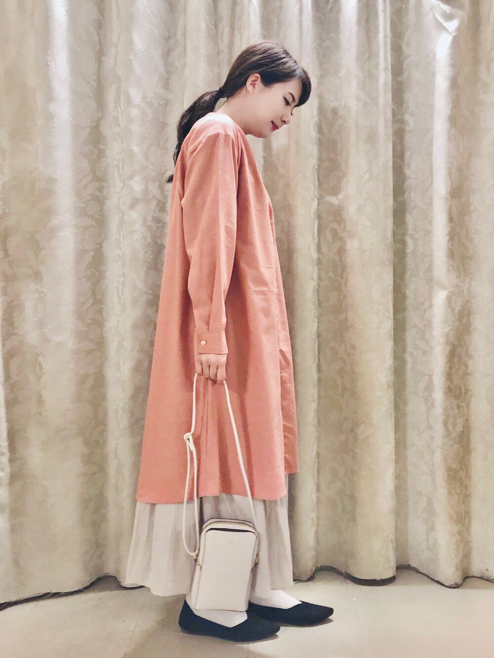 ピンク系のワンピース、ホワイト系のショルダーバッグ、ブラック系のパンプスを着用したレディースの春コーディネートの2枚目の写真