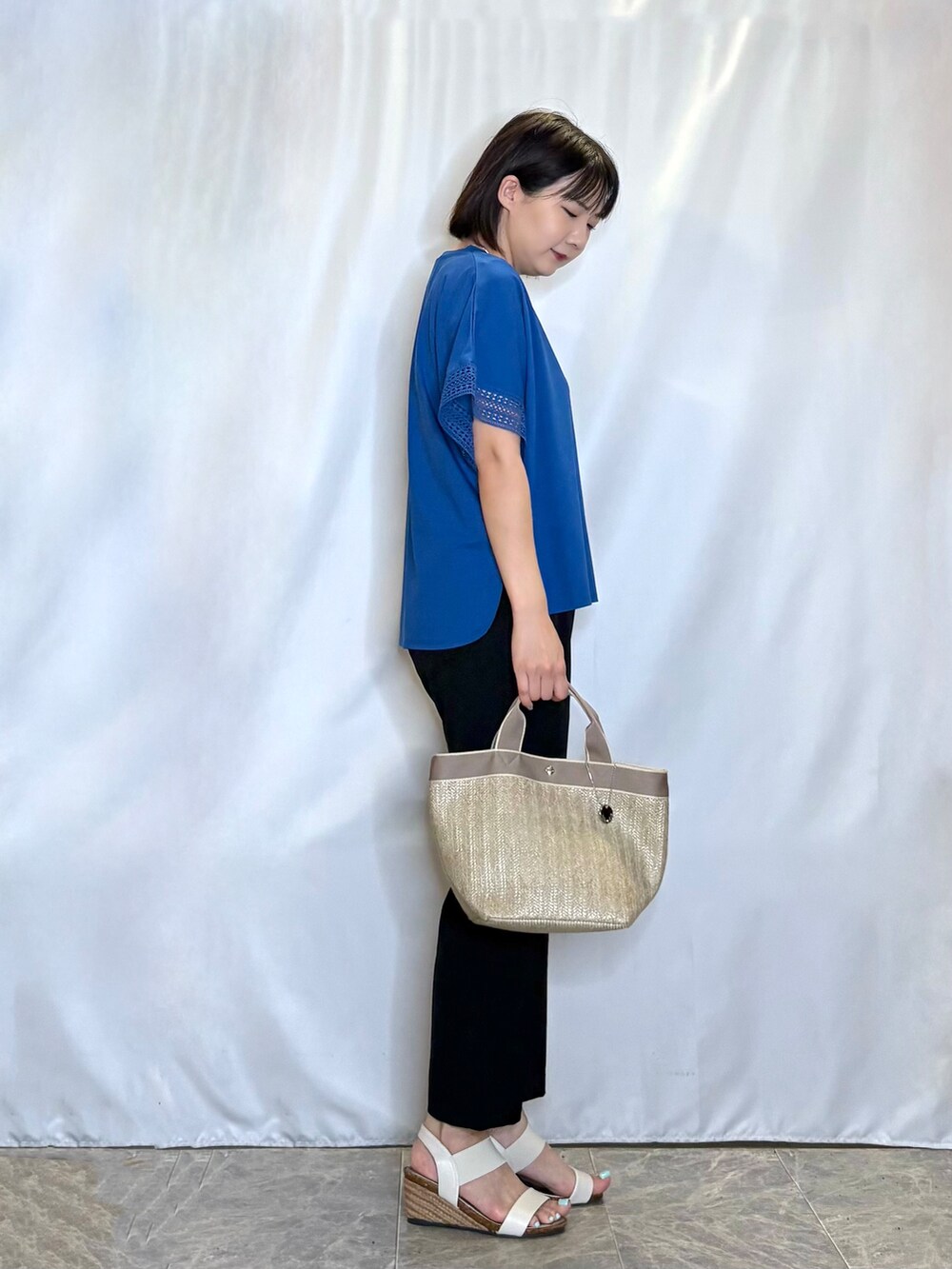 ブルー系のTシャツ/カットソー、ブラック系のその他パンツ、ホワイト系のサンダルを着用したレディースの夏コーディネートの2枚目の写真