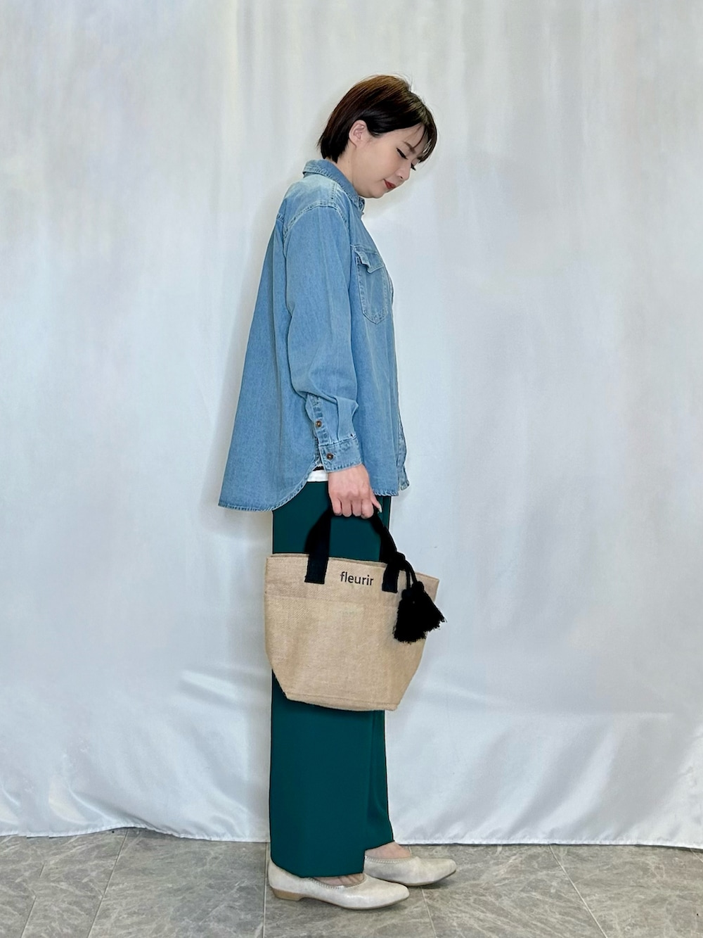 ブラック系のトートバッグ、ゴールド系のその他シューズ、グリーン系のその他パンツを着用したレディースの春コーディネートの2枚目の写真