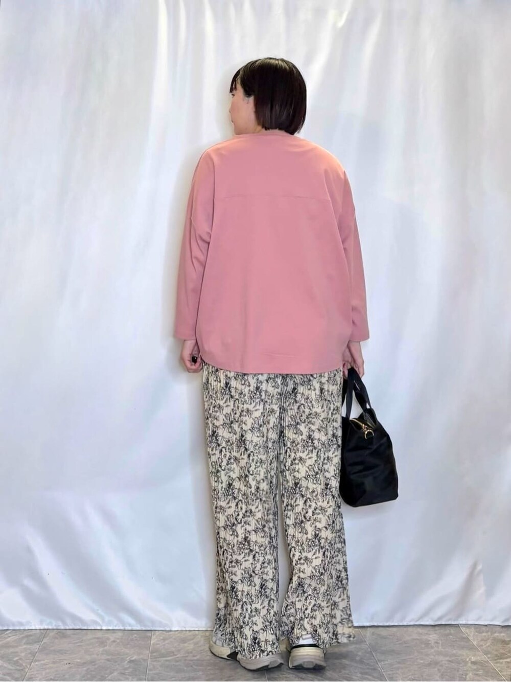 ピンク系のTシャツ/カットソー、ベージュ系のその他パンツ、ブラック系のトートバッグを着用したレディースの春コーディネートの3枚目の写真