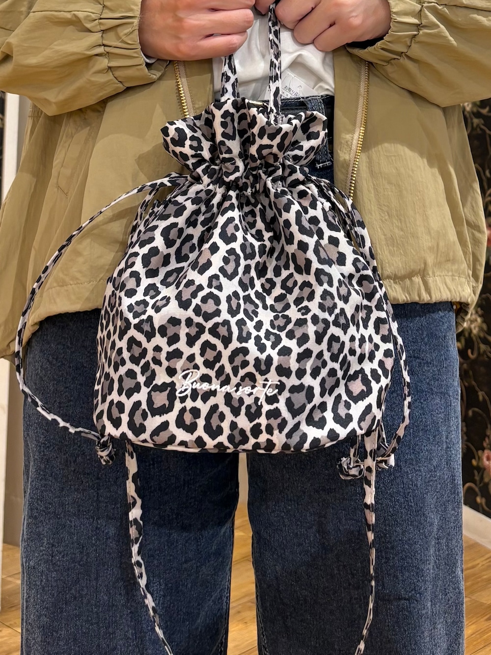 ベージュ系のブルゾン、ホワイト系のTシャツ/カットソー、ブルー系のデニムパンツを着用したレディースの秋コーディネートの5枚目の写真