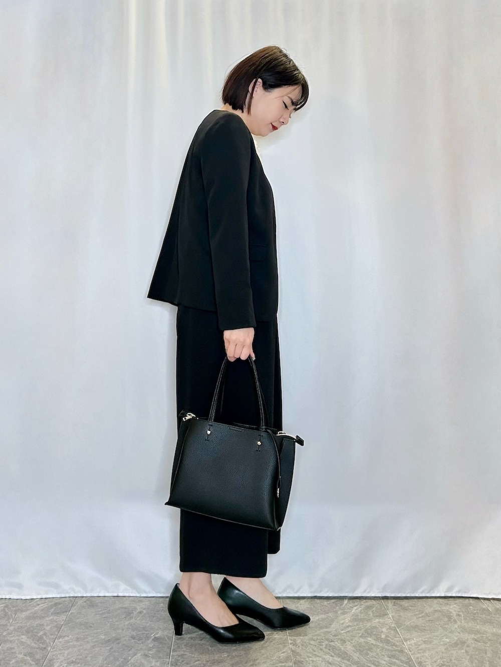 ブラック系のパンプス、ブラック系のその他パンツ、ブラック系のトートバッグを着用したレディースの冬コーディネートの2枚目の写真