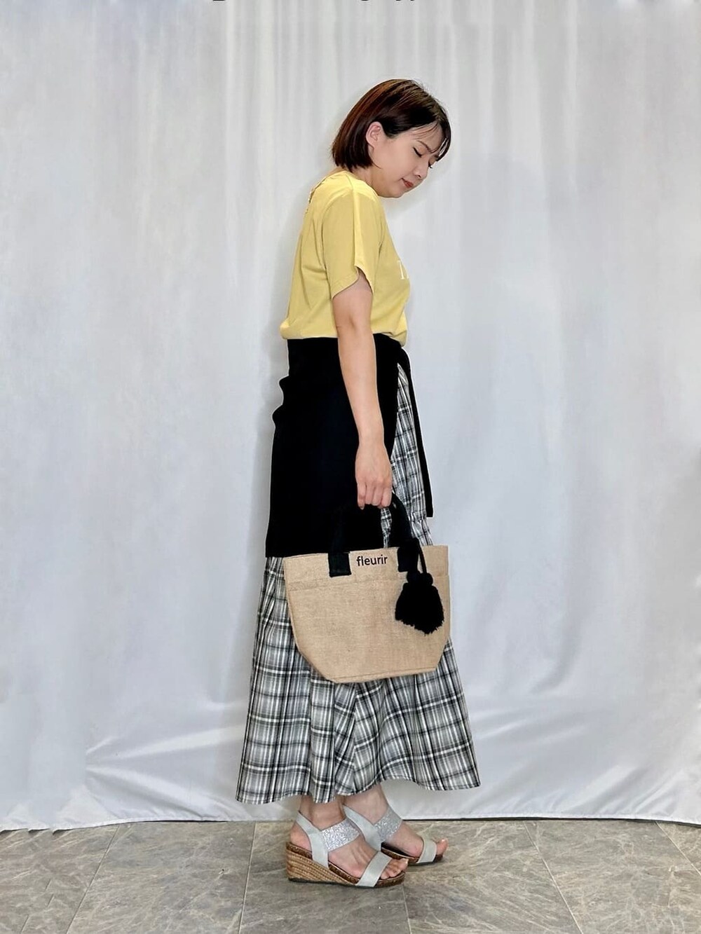 ブラック系のカーディガン/ボレロ、イエロー系のTシャツ/カットソー、ブラック系のスカートを着用したレディースの夏コーディネートの2枚目の写真