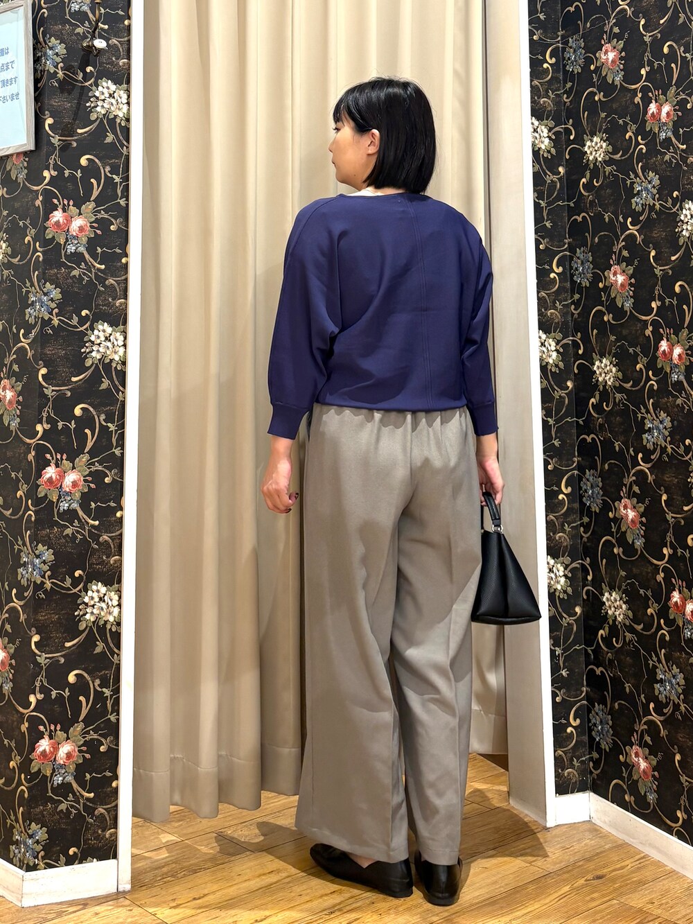 ブルー系のニット/セーター、ベージュ系のその他パンツ、ブラック系のショルダーバッグを着用したレディースの秋コーディネートの3枚目の写真