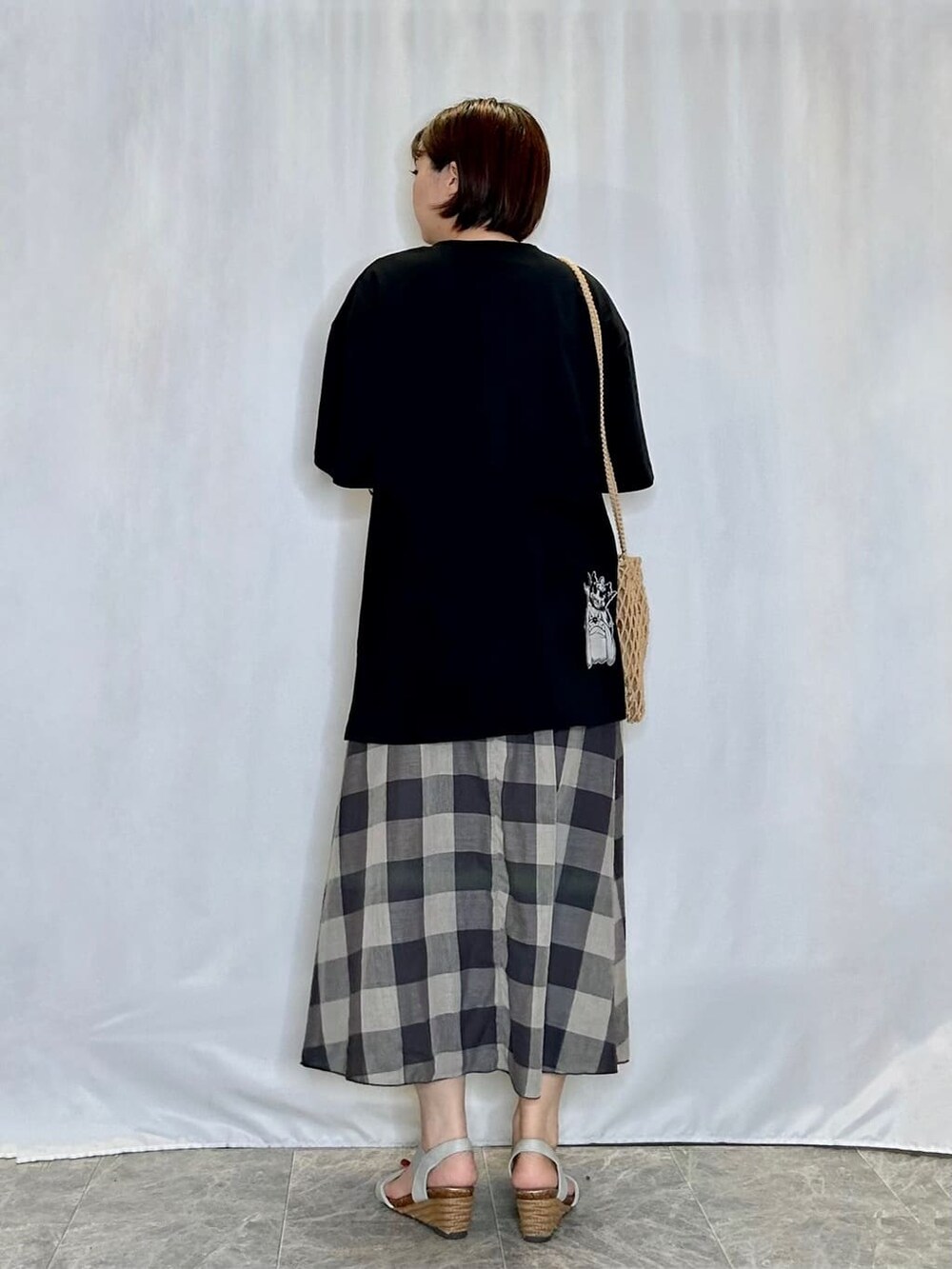 ブラック系のTシャツ/カットソー、グレー系のスカート、シルバー系のサンダルを着用したレディースの夏コーディネートの3枚目の写真