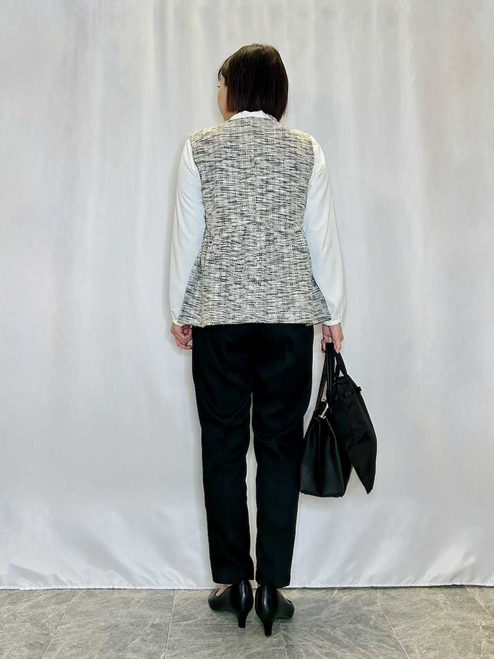 ブラック系のパンプス、ブラック系のトートバッグ、ブラック系のその他パンツを着用したレディースの冬コーディネートの3枚目の写真