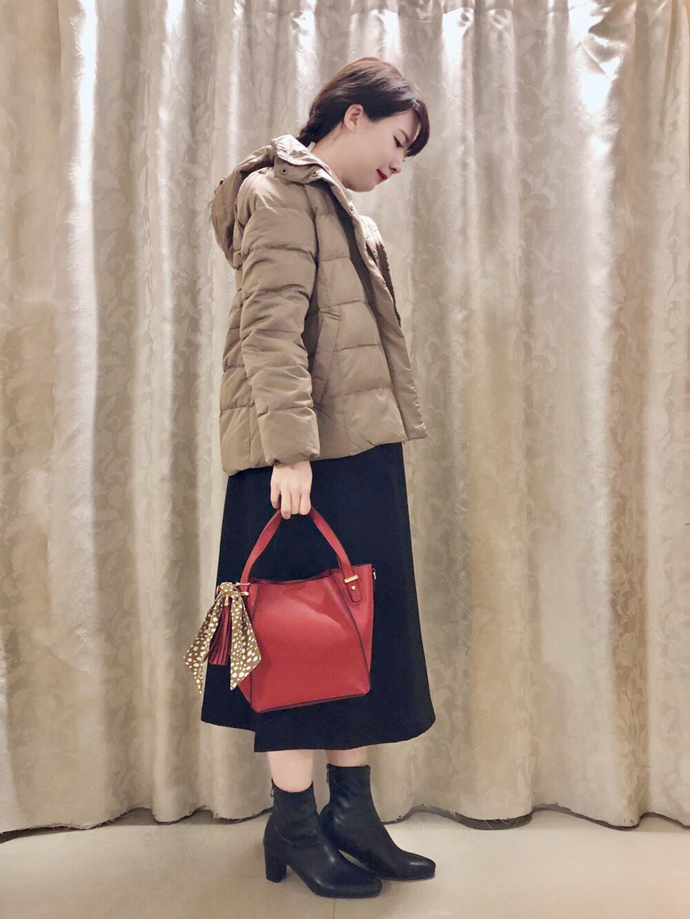 ブラック系のスカート、ベージュ系のTシャツ/カットソー、レッド系のショルダーバッグを着用したレディースの秋コーディネートの2枚目の写真