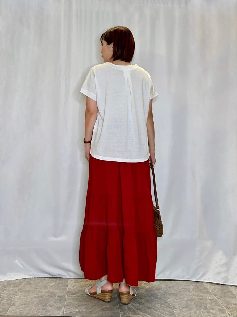ホワイト系のTシャツ/カットソー、レッド系のスカート、シルバー系のサンダルを着用したレディースの夏コーディネートの3枚目の写真