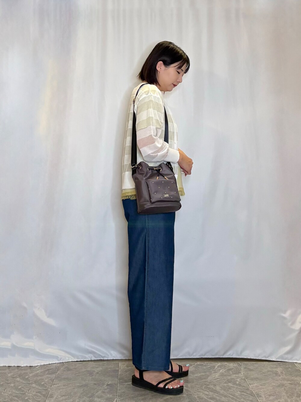 ホワイト系のカーディガン/ボレロ、イエロー系のTシャツ/カットソー、ブルー系のデニムパンツを着用したレディースの夏コーディネートの3枚目の写真